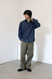 Person wearing a blue shirt and Khaki Green pants in a minimalistic setting