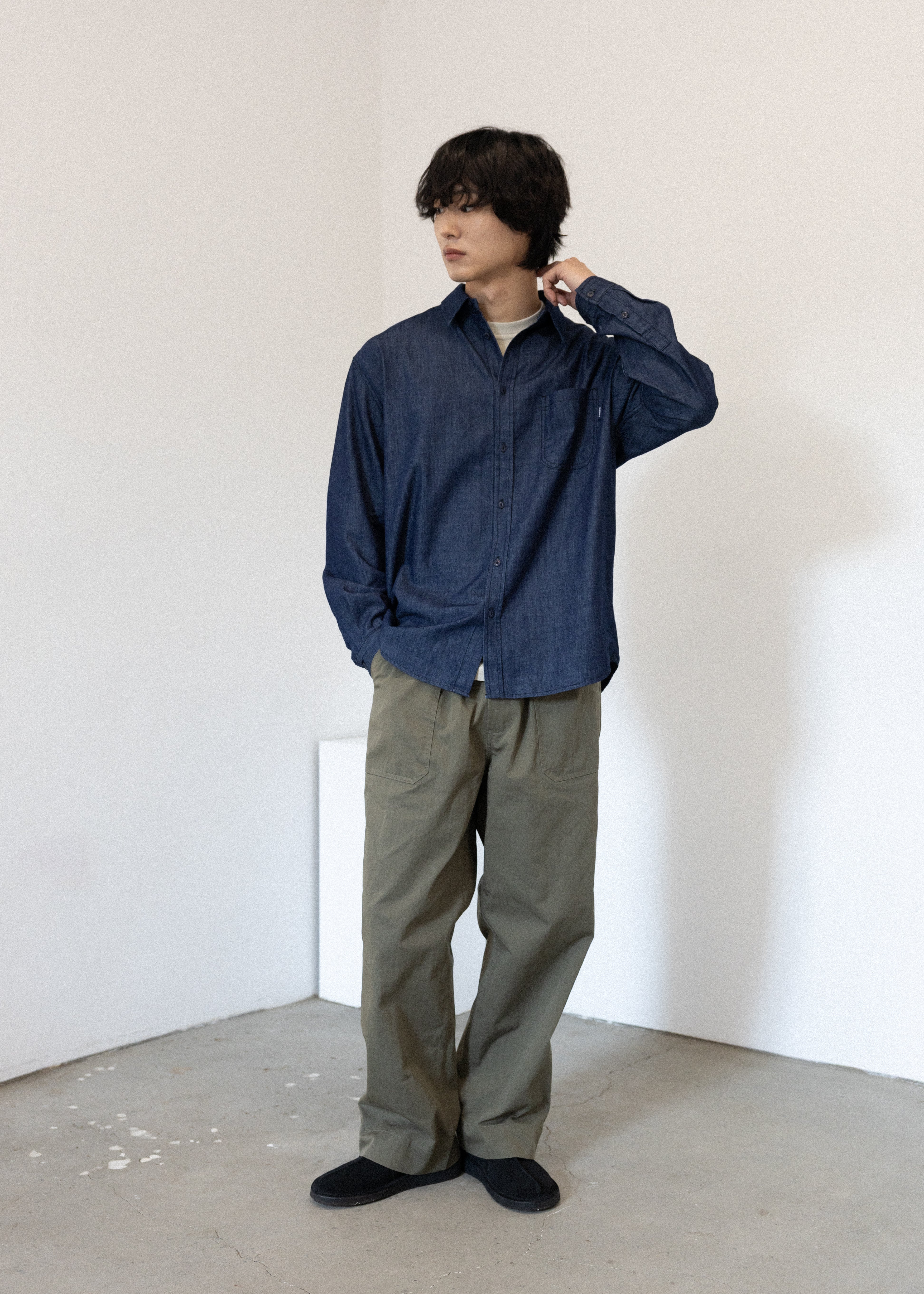 Person wearing a blue shirt and Khaki Green pants in a minimalistic setting