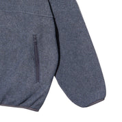 Close-up of a dark gray fleece jacket showing a side zippered pocket and sleeve detail against a white background.