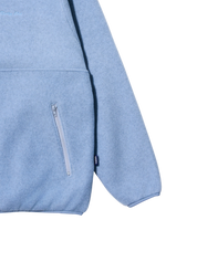 Close-up detail of a light blue heathered fleece hoodie showing a side zippered pocket, ribbed cuffs, and a small black brand tag on the sleeve.