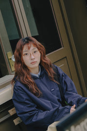 Person wearing a blue jacket sitting on a chair