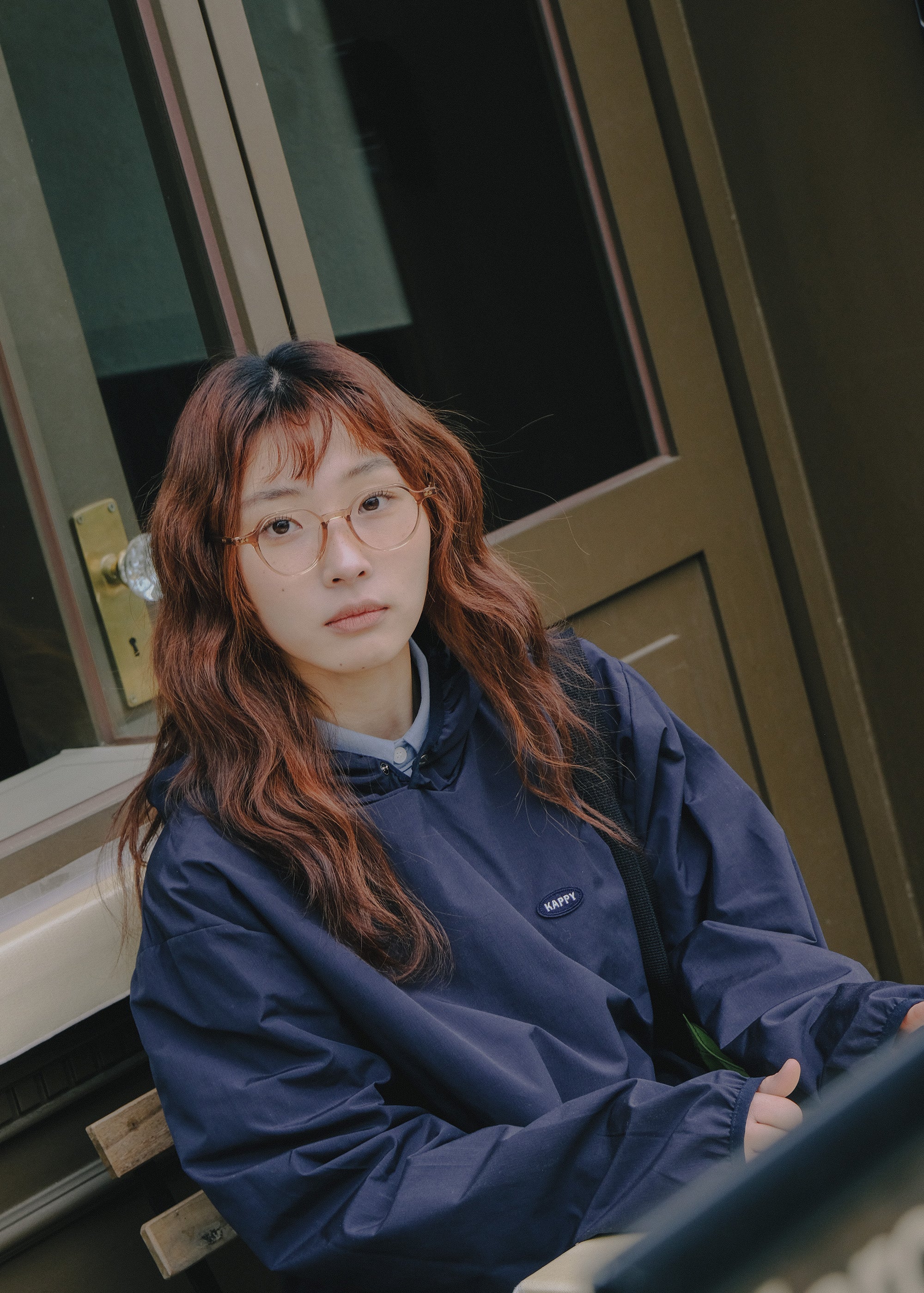 Person wearing a blue jacket sitting on a chair