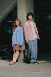 Two people standing together in an urban setting with a dark background