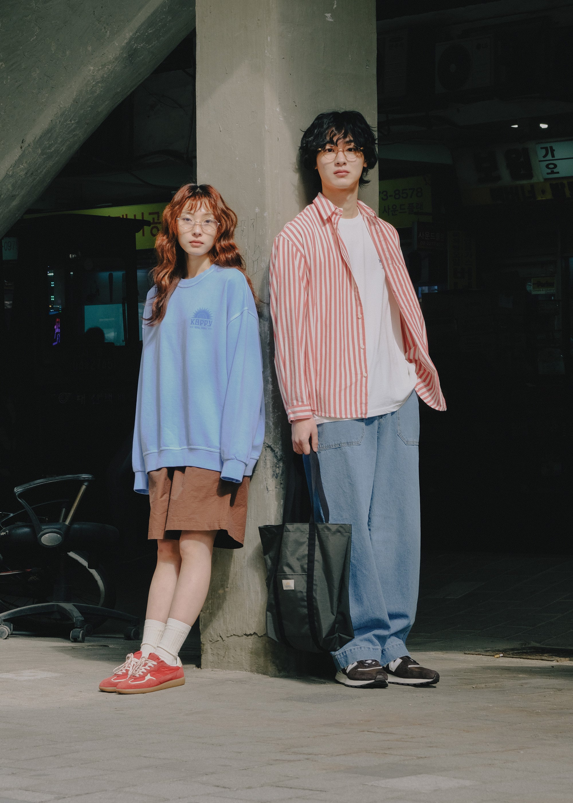 Two people standing together in an urban setting with a dark background