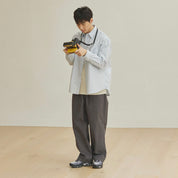 Person holding a camera against a plain background