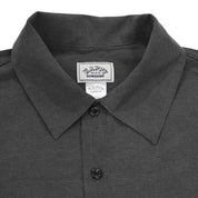 Close-up of a dark gray shirt collar with a brand label on a white background