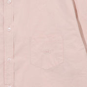 Close-up of a light pink shirt with a pocket and button details.