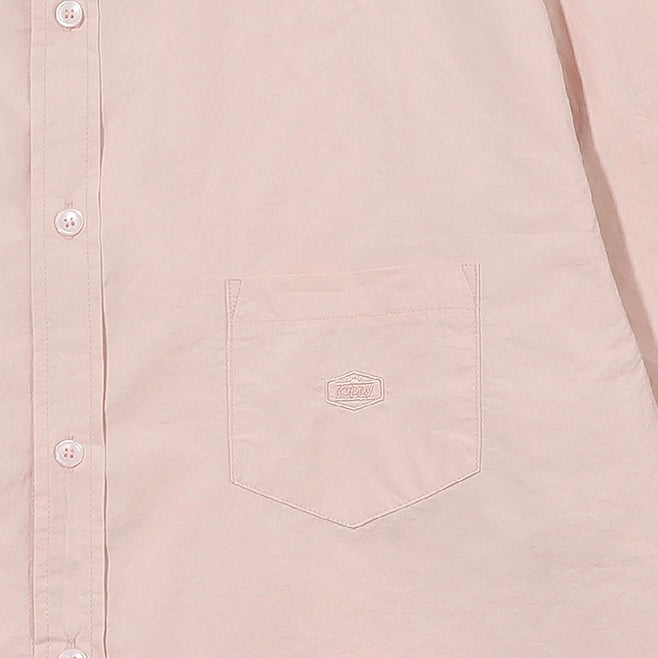 Close-up of a light pink shirt with a pocket and button details.