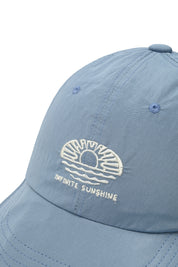 Zoom up of  light blue cap with "infinite sunshine" embroidery on front 