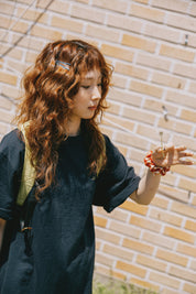 Woman with long wavy hair standing against a brick wall
