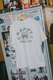 cream t-shirt with graphic design on a refrigerator with magnets and photos.