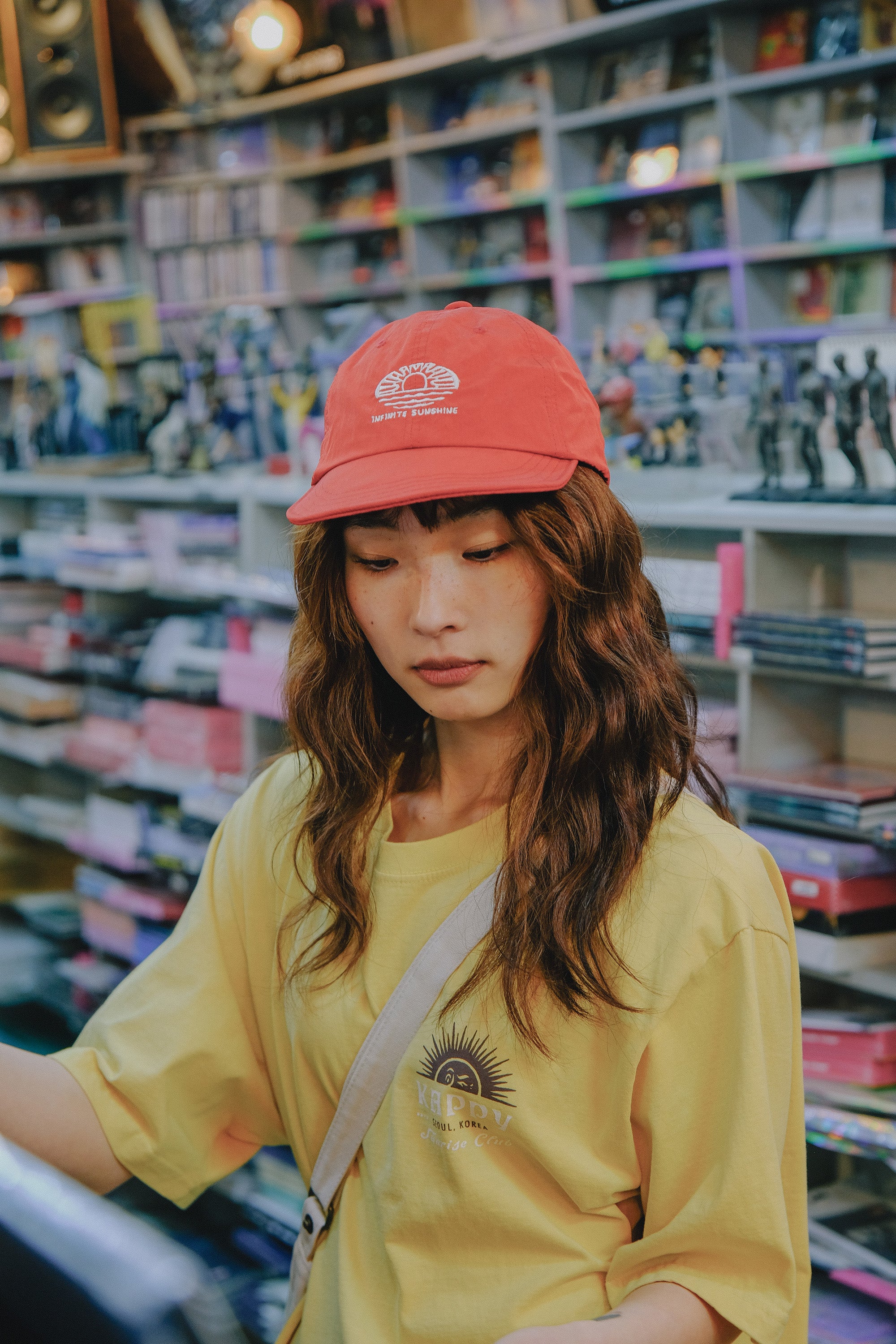 Person wearing a red cap and yellow shirt in a store setting