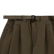 close up of Brown pleated waistband of trouser with a belt on a white background