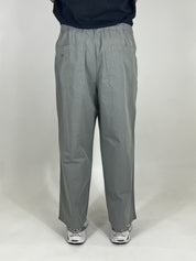 Person wearing grey pants on a white background