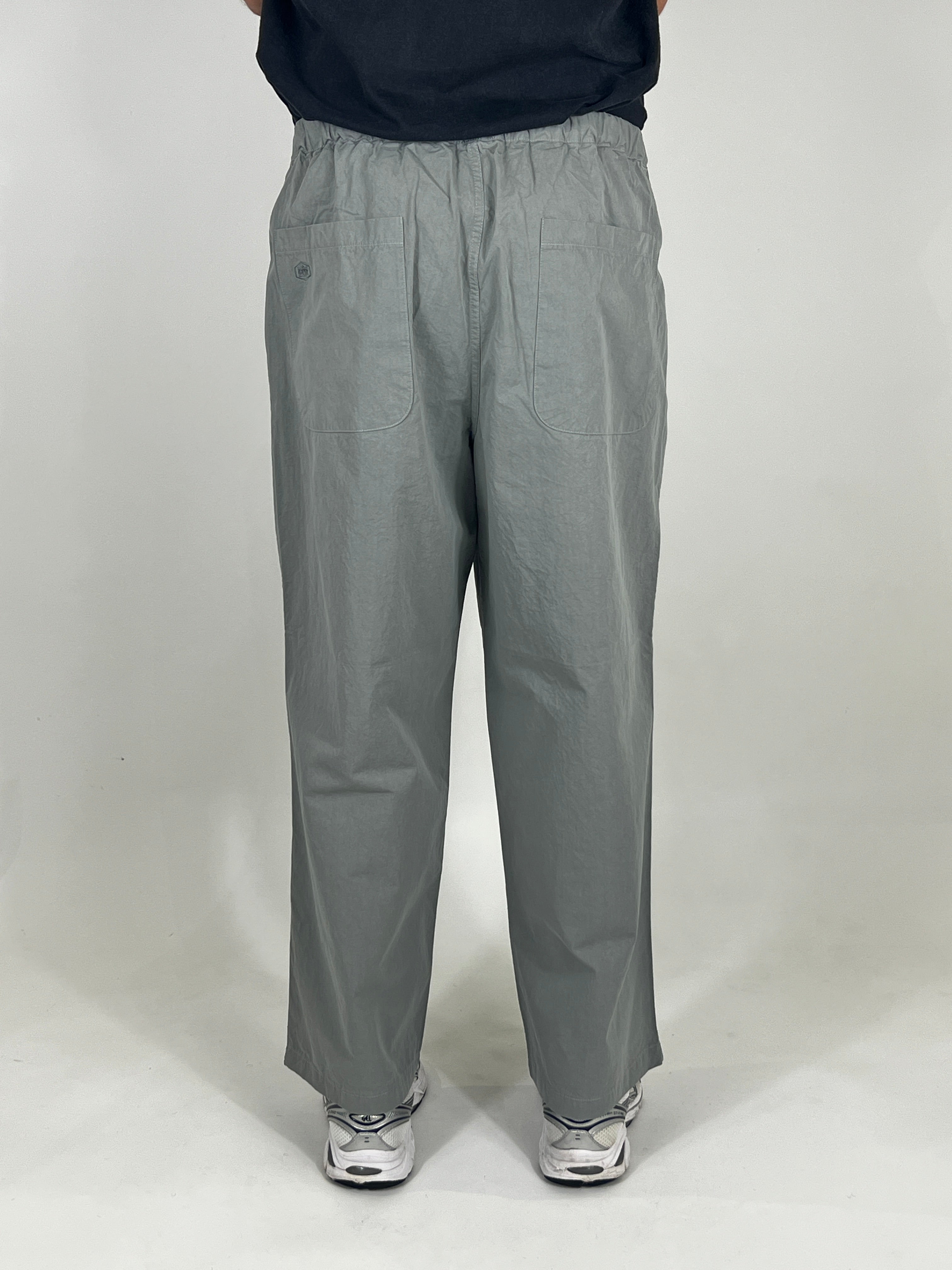 Person wearing grey pants on a white background