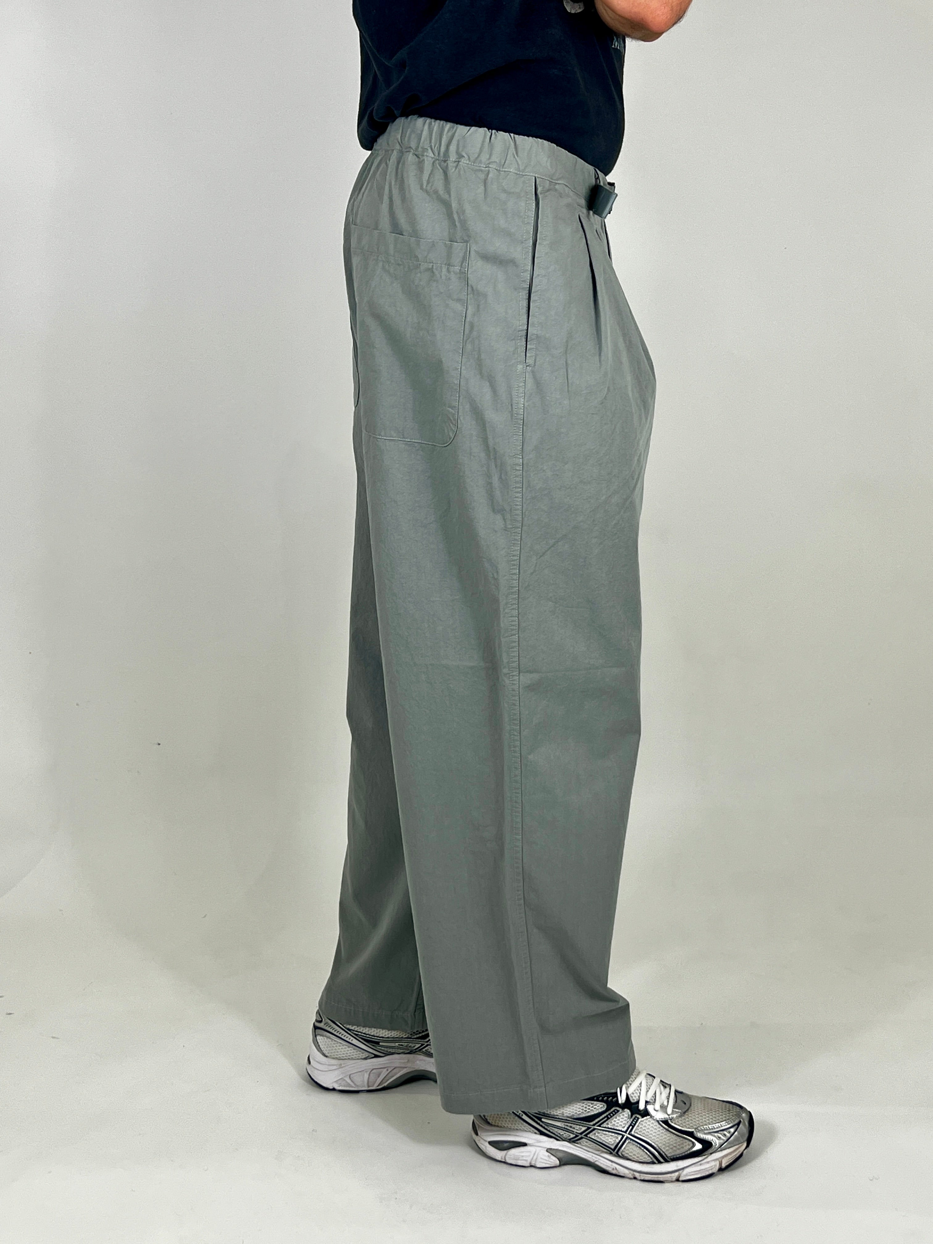 Person wearing grey pants on a plain background