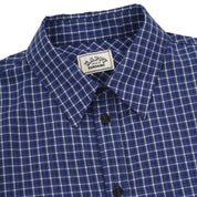 close up of Blue and white checkered shirt with a visible brand label on a white background