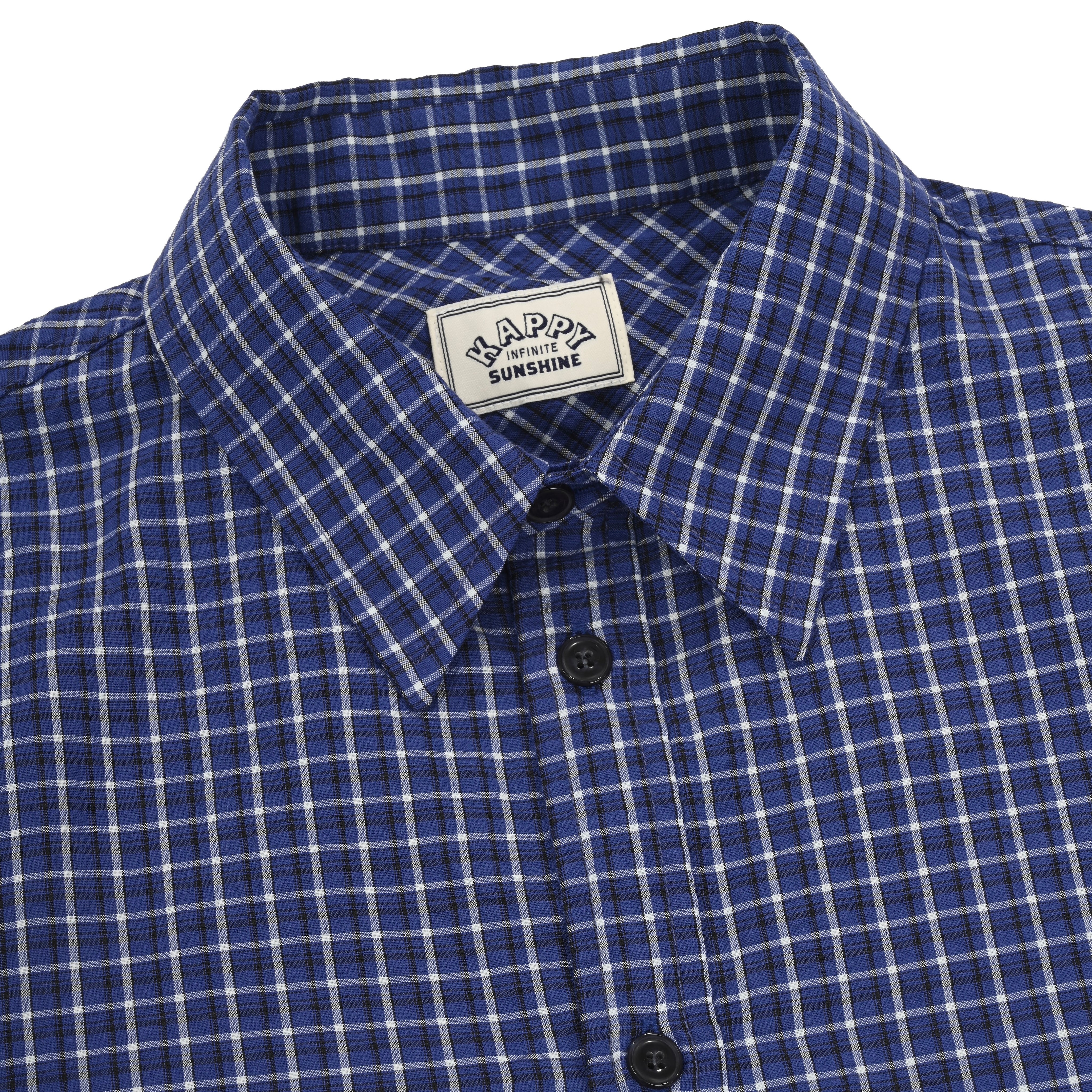 close up of Blue and white checkered shirt with a visible brand label on a white background