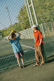 Two people on a tennis court with a net in the background
