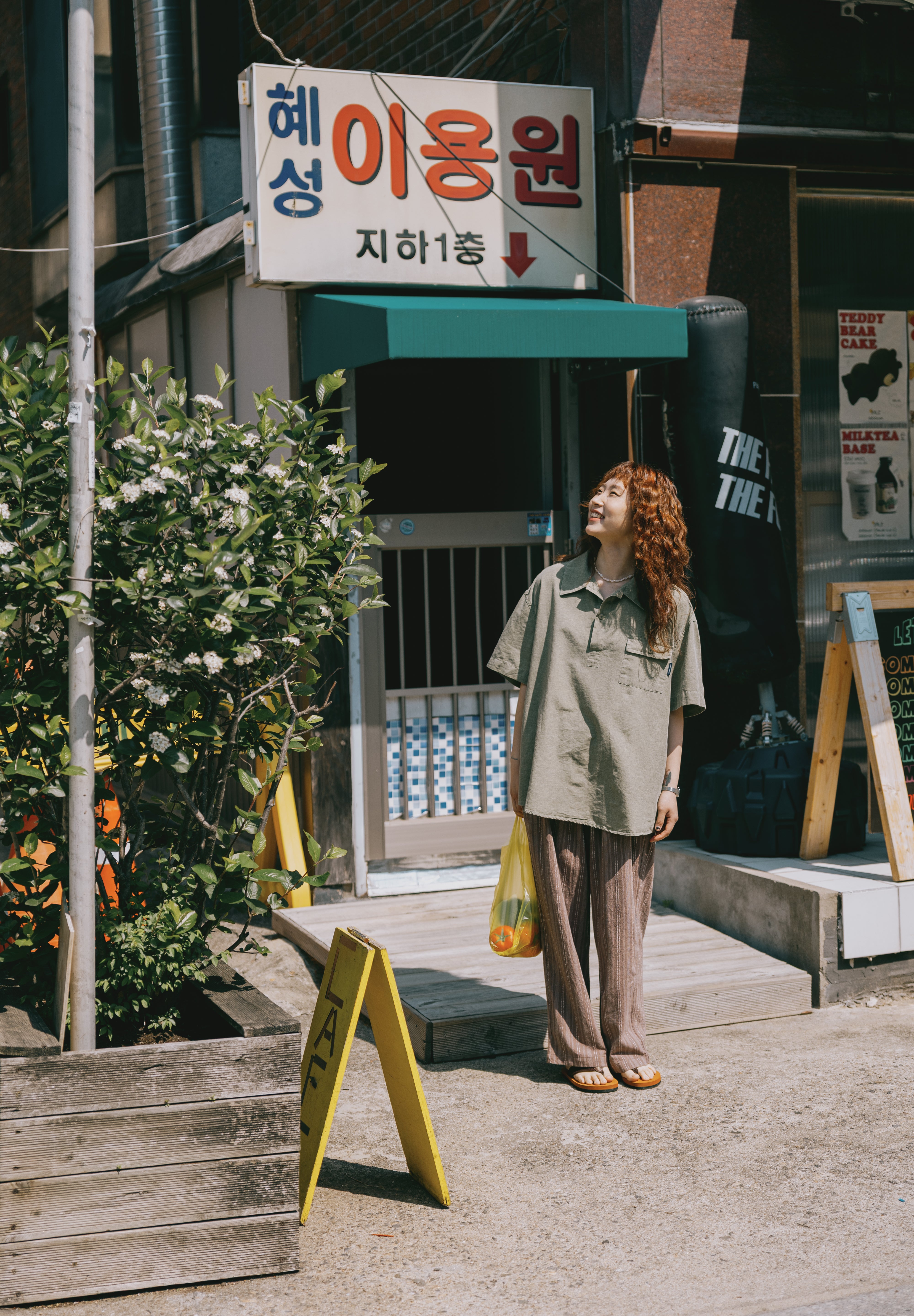 girl in Pigment Henley shirt standing on a street looking up to the sky